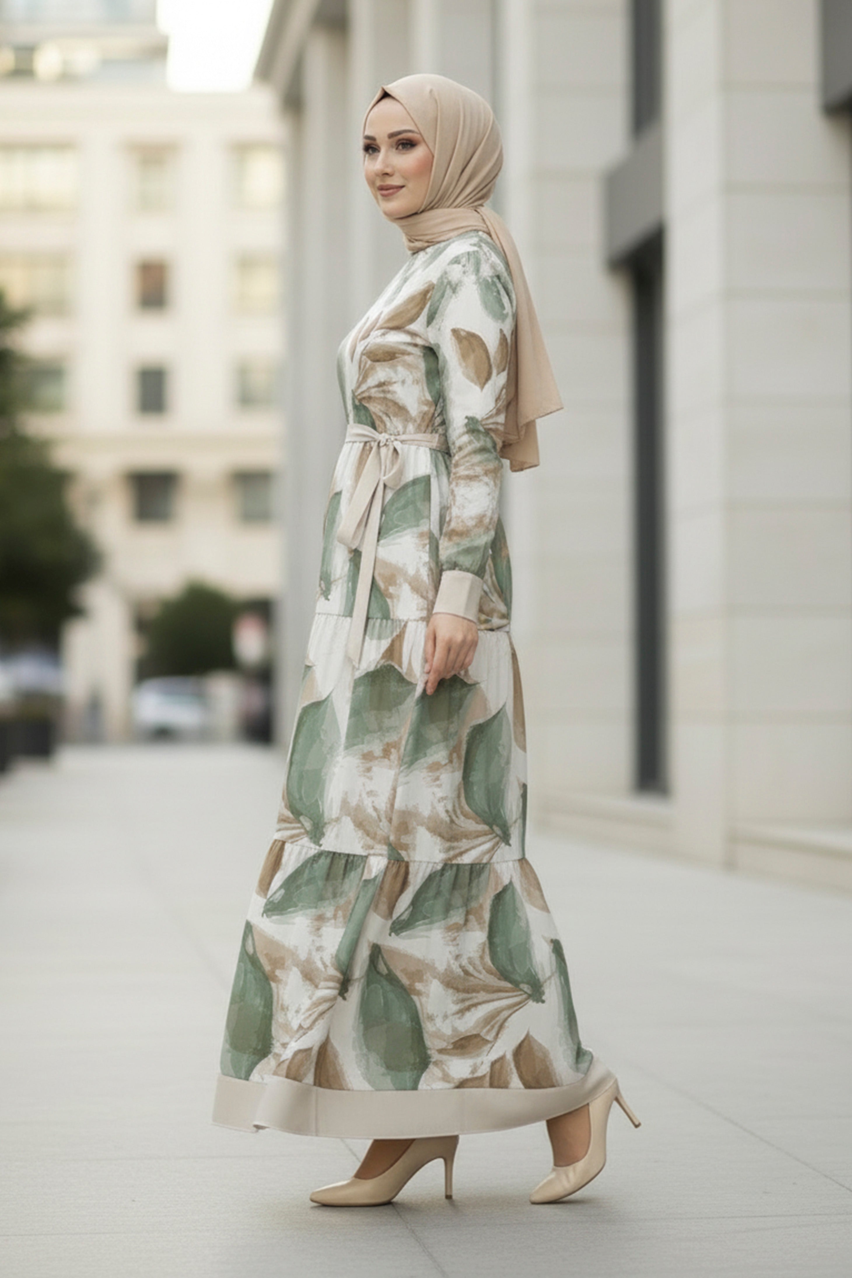 Woman wearing a floral dress and hijab standing on a city street.